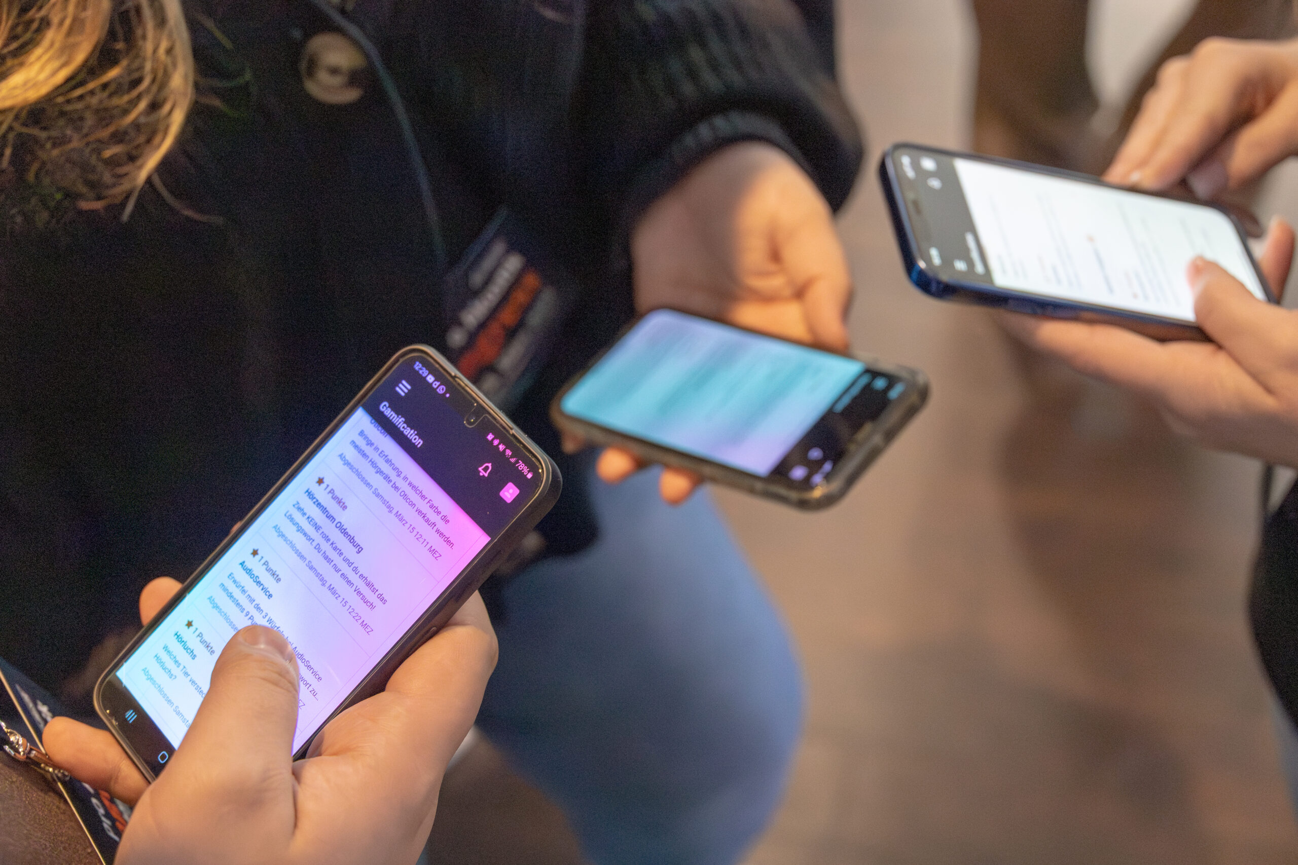 Smartphones mit Social-Media-Beiträgen in den Händen von Teilnehmenden